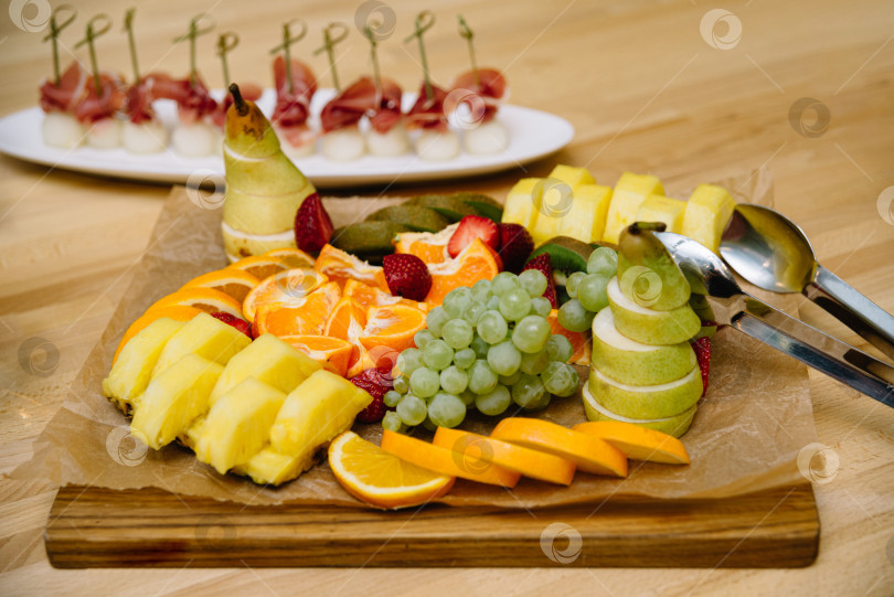 Скачать Блюдо из свежих фруктов с ассорти на деревянной доске фотосток Ozero
