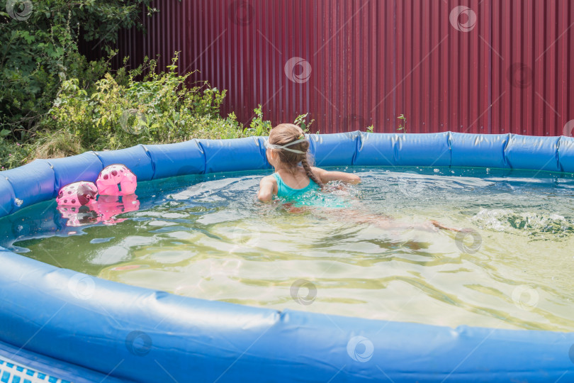 Скачать Девочка в голубом купальнике  плавает в бассейне фотосток Ozero
