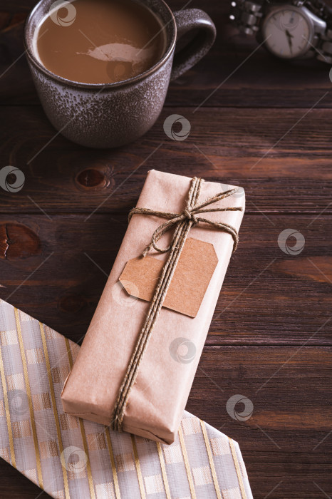 Скачать Подарок на день отца своими руками с сердечком на галстуке, кофейная кружка на деревянном столе в вертикальном положении фотосток Ozero