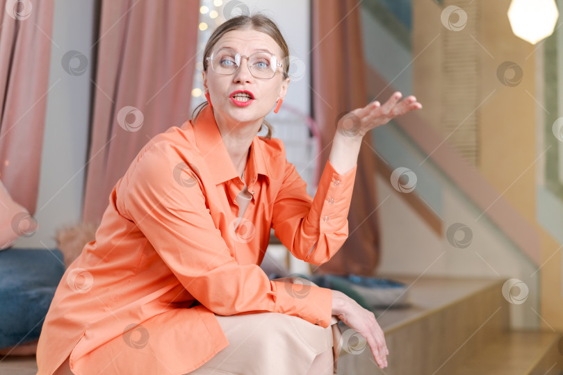 Скачать На деревянной ступеньке сидит женщина в оранжевой рубашке фотосток Ozero