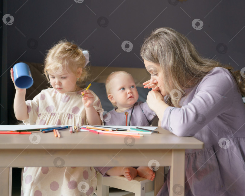 Скачать Молодая мать выражает любовь маленькому сыну, играя с детьми дома фотосток Ozero