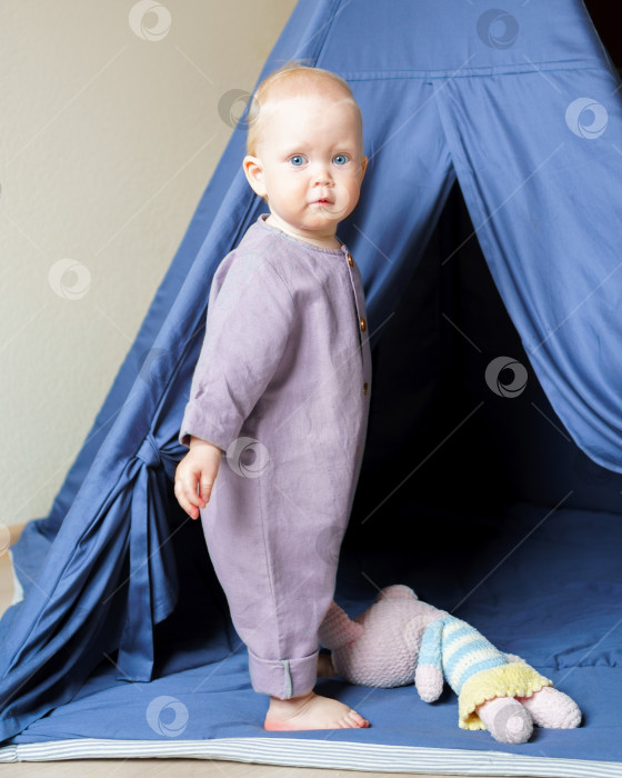 Скачать Очаровательный маленький ребенок стоит в игровой палатке с игрушками фотосток Ozero