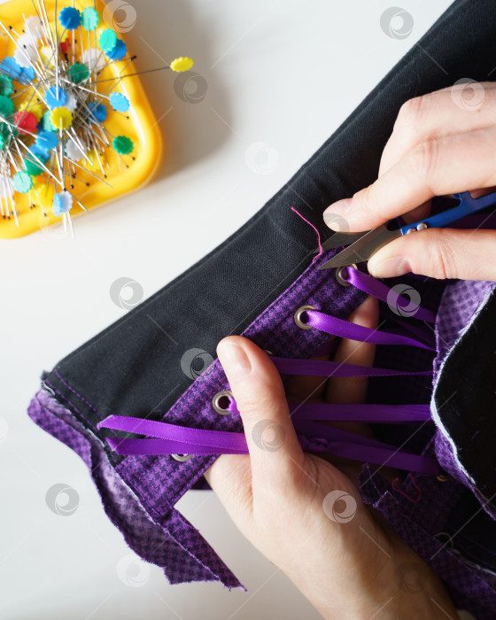 Скачать Женщина-швея или портной использует ножницы при шитье корсета фотосток Ozero