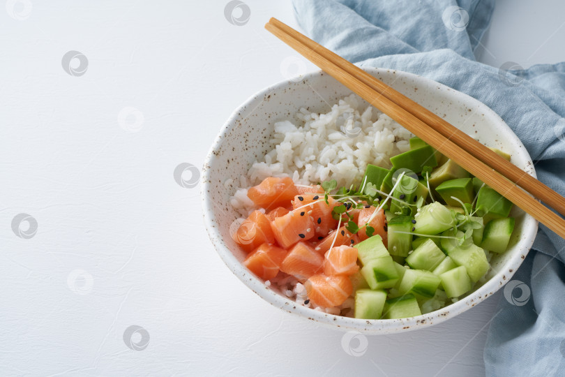 Скачать поке-боул из лосося со свежей рыбой, рисом, огурцом и авокадо фотосток Ozero