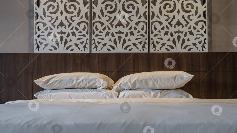 Скачать Большая двуспальная кровать аккуратно застелена белыми простынями. фотосток Ozero