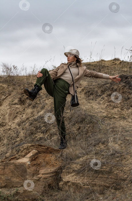 Скачать Женщина  занимается йогой на скале, на фоне неба. фотосток Ozero