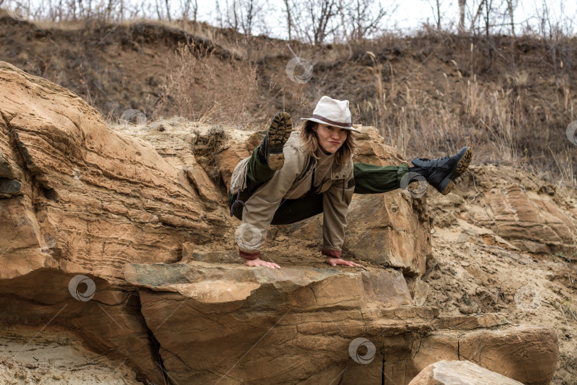 Скачать Женщина в шляпе стоит на руках на краю скалы. фотосток Ozero