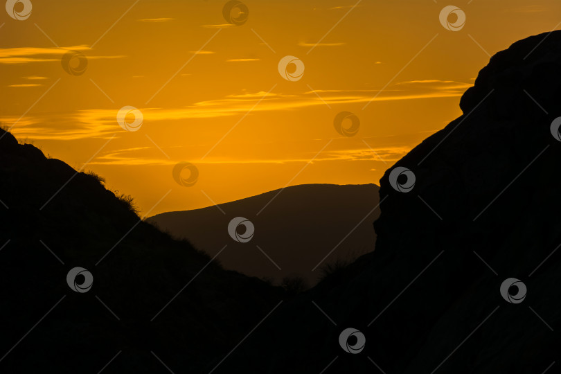 Скачать Закат в горах. молодая влюбленная пара, парень и девушка, стоят на вершине горы во время заката, силуэты людей. фотосток Ozero