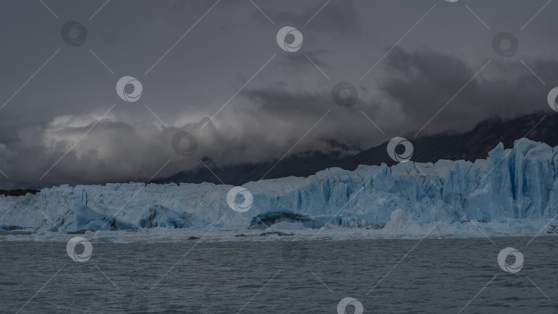 Скачать Стена из голубого льда с трещинами, расселинами и острыми пиками фотосток Ozero