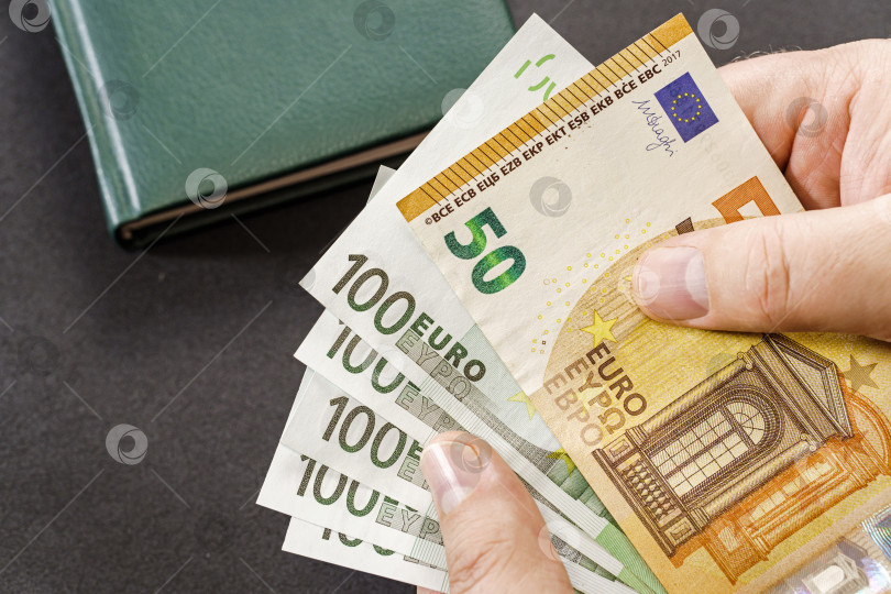 Скачать Держа наличные евро над столом фотосток Ozero