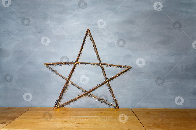 Скачать Декоративная звезда из веток с подсветкой на фоне Голубой стены фотосток Ozero