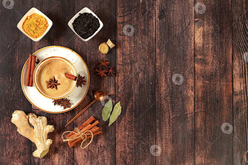 Скачать Традиционный напиток со специями, индийский масала-чай с молоком, имбирем, анисом и корицей на старинном деревянном столе. концепция кафе, реклама ресторана и меню. фотосток Ozero