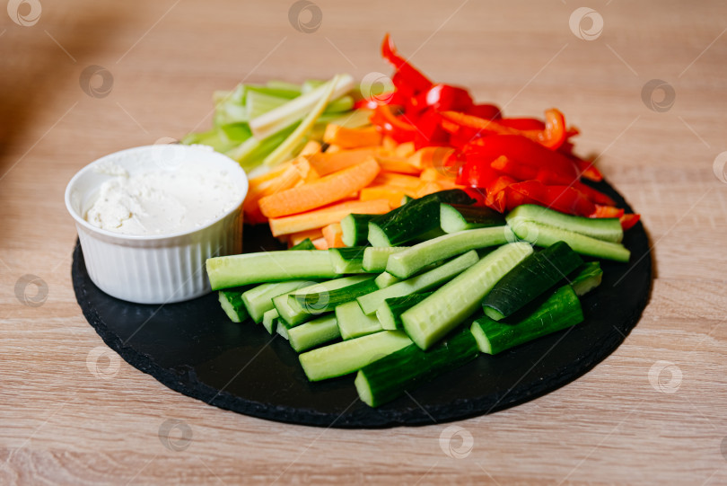 Скачать Свеженарезанные овощные палочки с соусом на грифельной доске фотосток Ozero