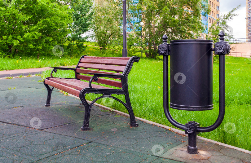 Скачать Деревянная скамейка и мусорный бак в городском парке фотосток Ozero