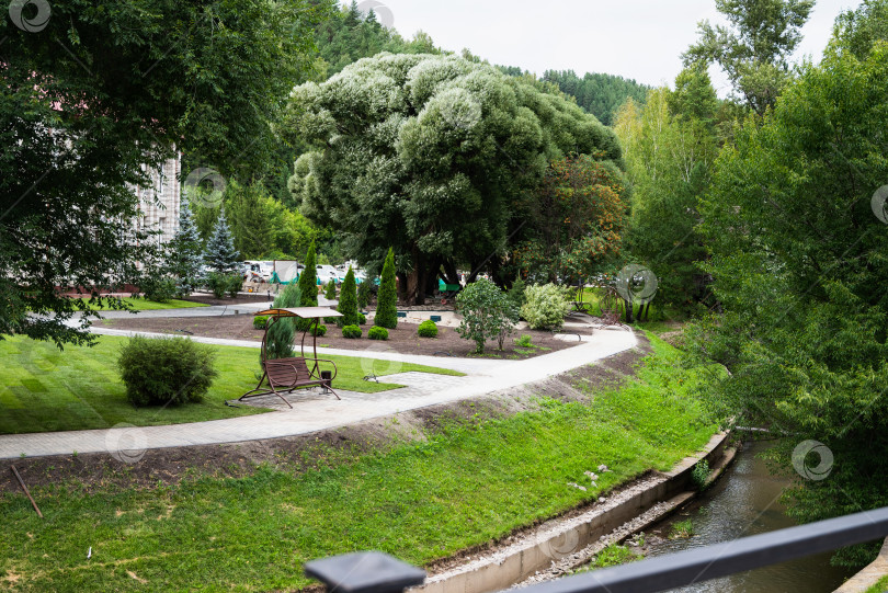 Скачать Уютный сад с декоративным озером и мостиком в летнее время. фотосток Ozero