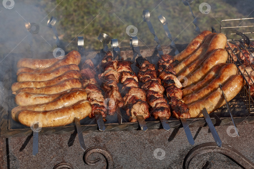 Скачать Мясо обжаривается на раскаленных углях в гриле. фотосток Ozero