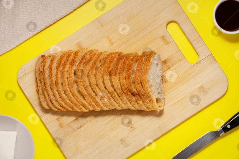 Скачать Хлеб чиабатта, нарезанный ломтиками на доске, вид сверху фотосток Ozero