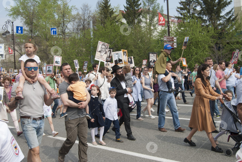 Скачать Тюмень, Россия, 9 мая 2019: Тюменцы с детьми и с фотографиями своих родственников в руках идут в рядах "Бессмертного полка" 9 мая фотосток Ozero