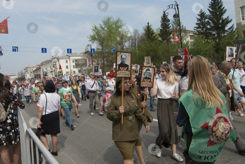 Скачать Тюмень, Россия, 9 мая 2019: Женщины в форме времен ВОВ и с фотографиями своих родственников в руках идут в рядах "Бессмертного полка" 9 мая фотосток Ozero