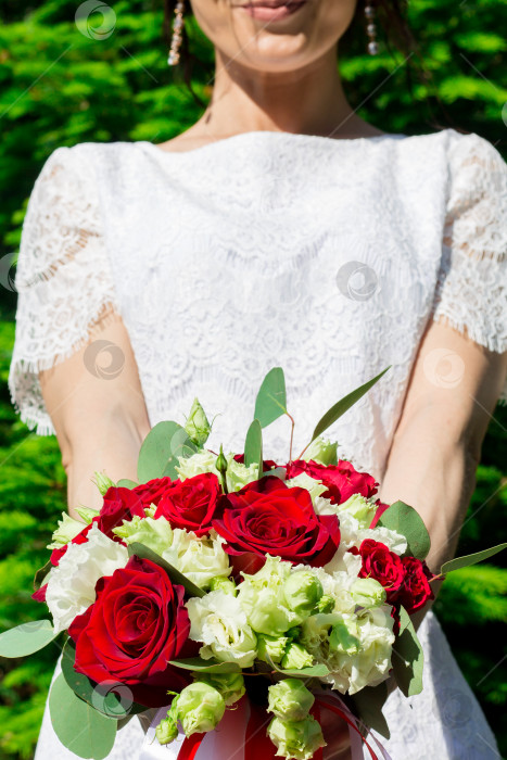 Скачать Свадебный букет из красных и белых роз в руках невесты фотосток Ozero