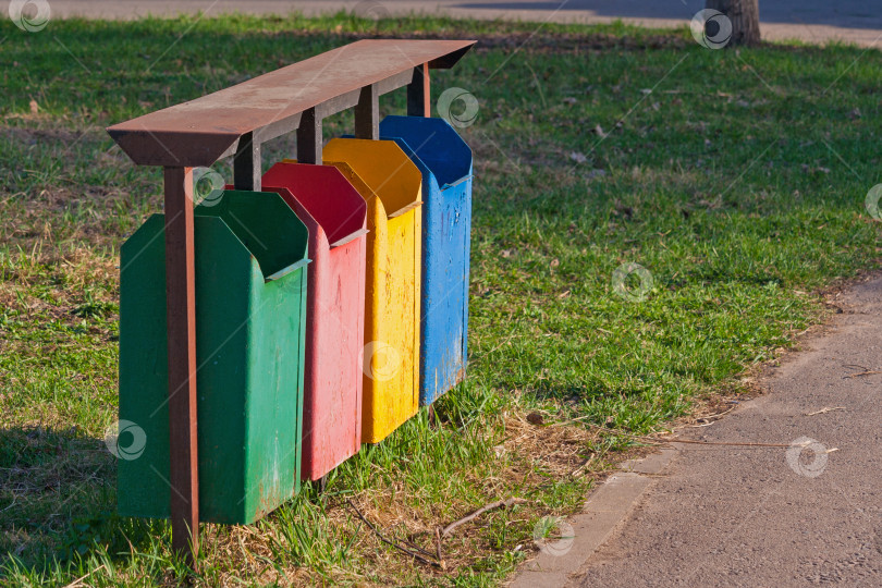 Скачать Четыре цвета грязных мусорных баков или мусорного ведра в парке фотосток Ozero