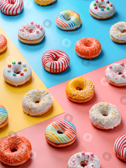 Скачать Глазированные разноцветные пончики на фоне, вид сверху фотосток Ozero