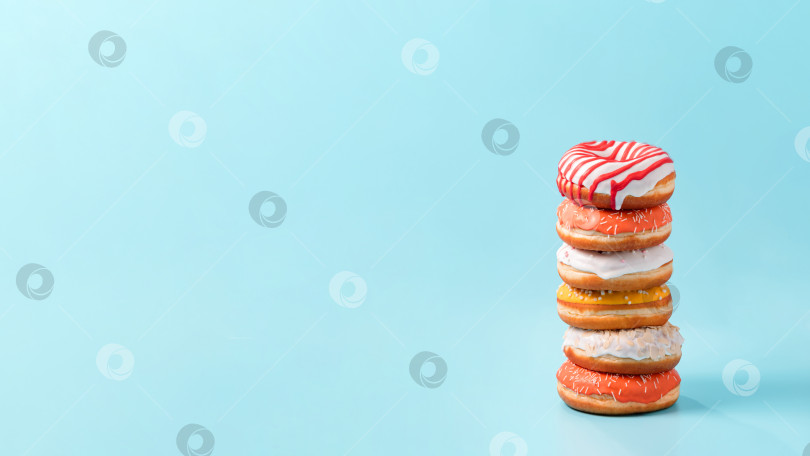 Скачать Стопка пончиков на синем фоне с пространством для копирования фотосток Ozero