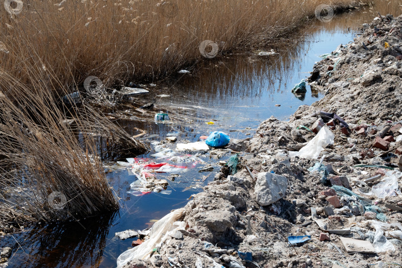 Скачать Куча мусора у воды - это загрязнение, наносящее вред природному ландшафту фотосток Ozero
