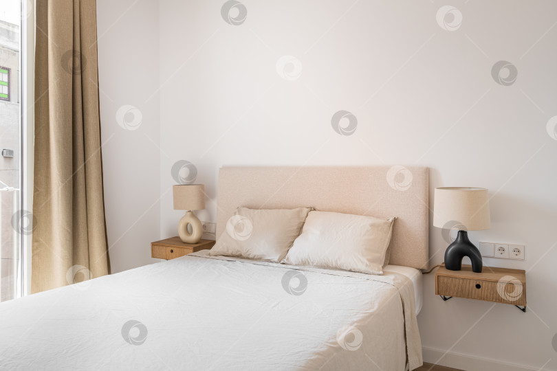 Скачать Двуспальная кровать с подушками и одеялом в минималистской спальне фотосток Ozero
