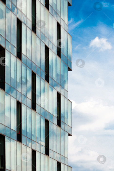 Скачать Современный фасад из стекла и стали на фоне голубого неба и облаков фотосток Ozero
