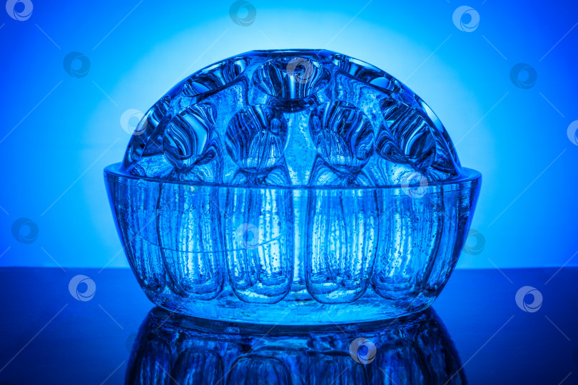 Скачать Декоративная полукруглая стеклянная ваза на фоне синего градиента фотосток Ozero