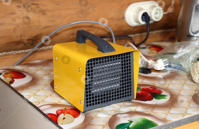 Скачать Электрический тепловентилятор на столе в деревенском доме фотосток Ozero
