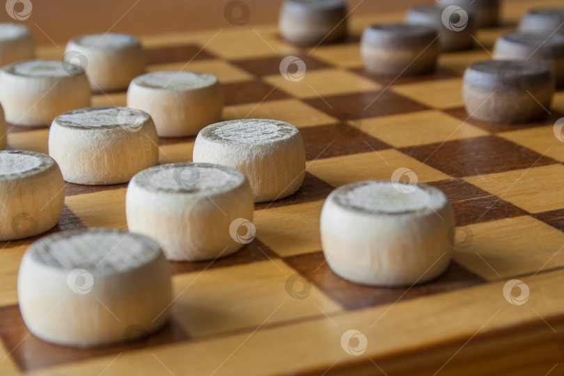 Скачать деревянная шахматная доска с расставленными на столе шашками (крупным планом) фотосток Ozero