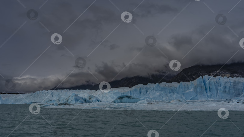 Скачать Стена голубого льда возвышается над ледниковым озером. фотосток Ozero