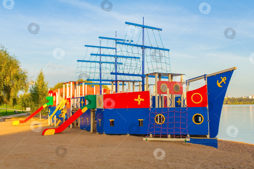 Скачать Красочная детская площадка в виде кораблика на берегу озера фотосток Ozero