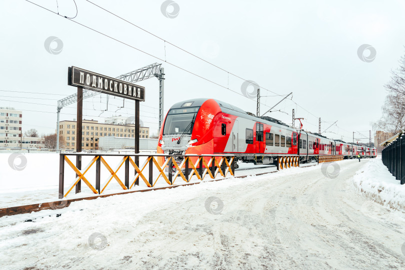 Скачать Москва, Россия - 29.12.2022: Красный пассажирский поезд на станции Подмосковная зимой фотосток Ozero