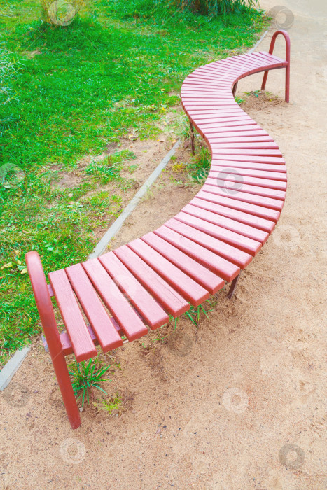 Скачать Вид сверху на деревянную скамейку необычной формы в виде буквы "S" в парке фотосток Ozero