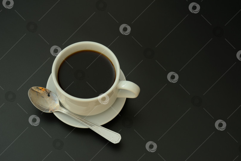 Скачать Чашка черного кофе с ложкой на блюдце на черном изолированном фоне. фотосток Ozero