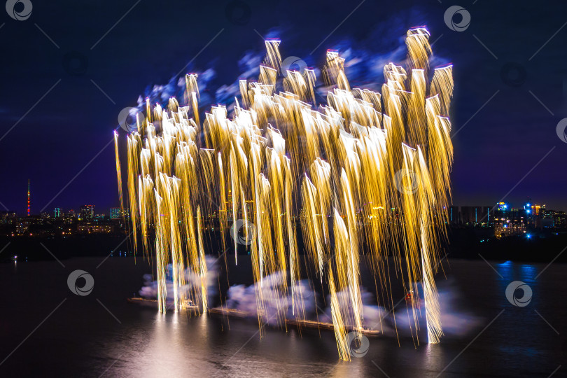 Скачать Золотой фейерверк над водой на фоне темного неба. фотосток Ozero