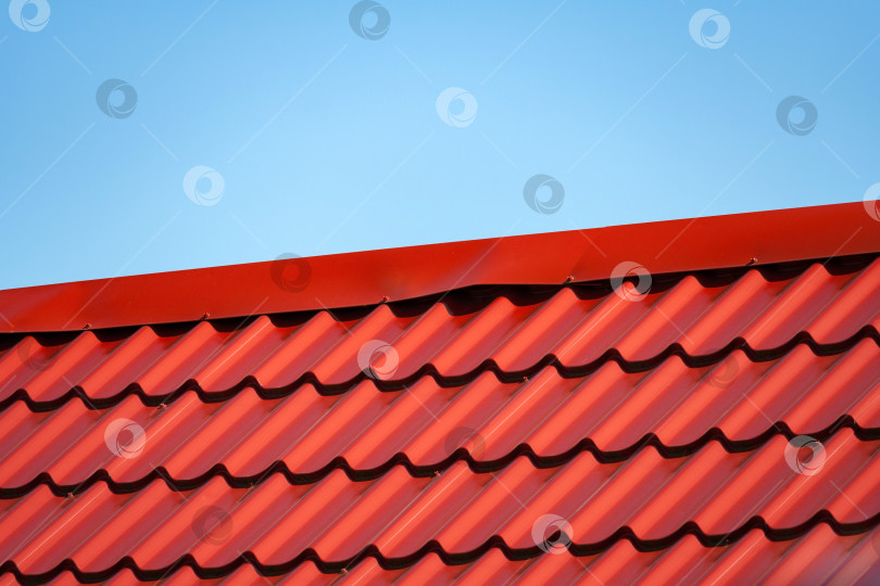 Скачать Фрагмент красной металлочерепичной крыши на фоне голубого неба фотосток Ozero