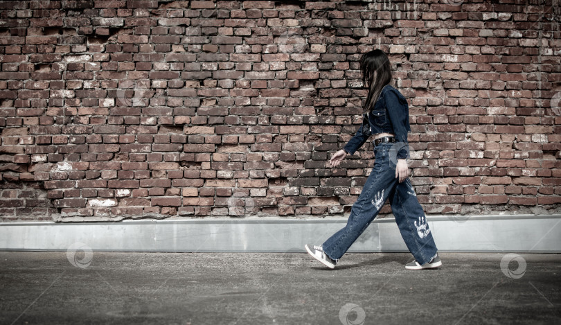 Скачать Молодая девушка прогуливается по парку рядом со старой крепостью фотосток Ozero