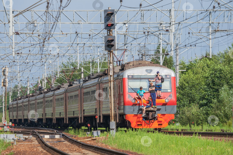 Скачать Московская область, РОССИЯ, август 2017 года: Подростки бесплатно катаются на внешней стороне хвостового вагона поезда фотосток Ozero