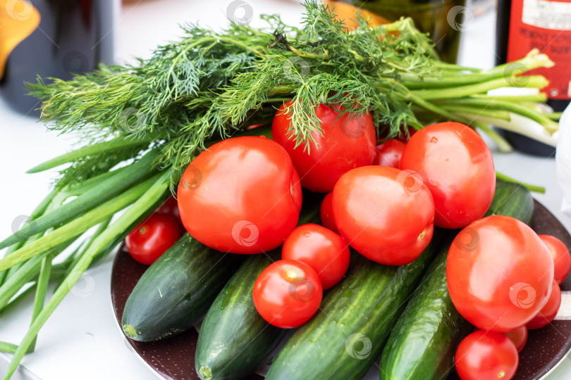 Скачать Тарелка из натуральных продуктов с помидорами черри, огурцами и зеленым луком фотосток Ozero