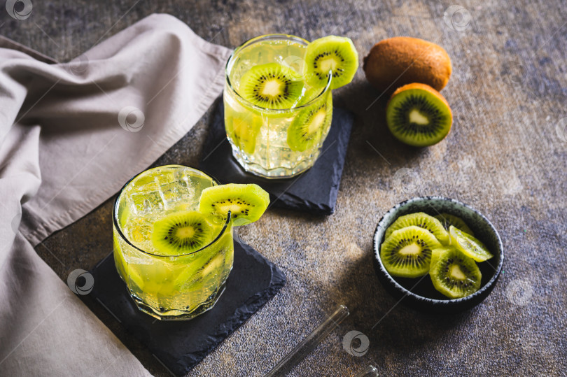 Скачать Освежающий тропический напиток мохито с киви в бокалах на столе фотосток Ozero