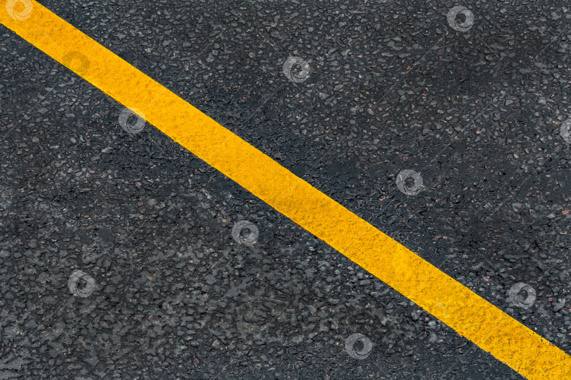 Скачать Желтая диагональная линия разметки на асфальтированной дороге (фон, текстура, абстракция) фотосток Ozero