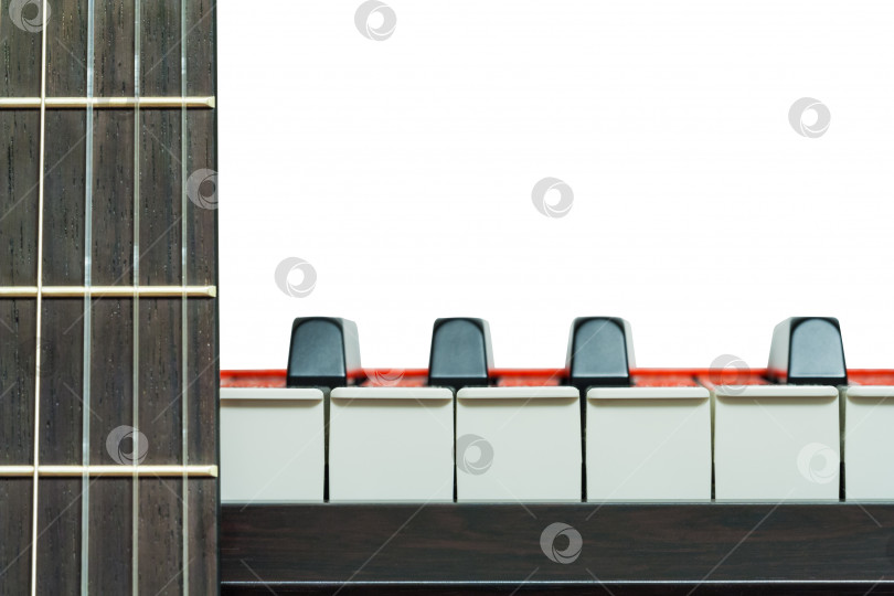 Скачать Клавиши пианино и фрагмент грифа гитары, вид спереди на белом фоне, крупным планом фотосток Ozero