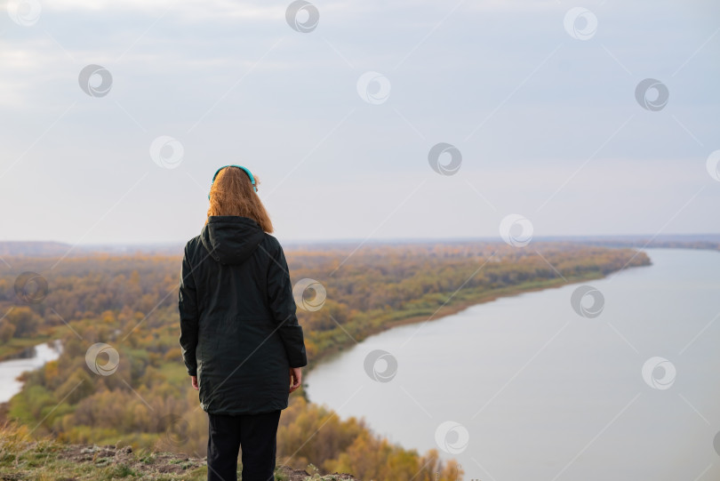 Скачать Женщина стоит на краю обрыва и смотрит на близлежащий остров, на море. Единение с природой. фотосток Ozero