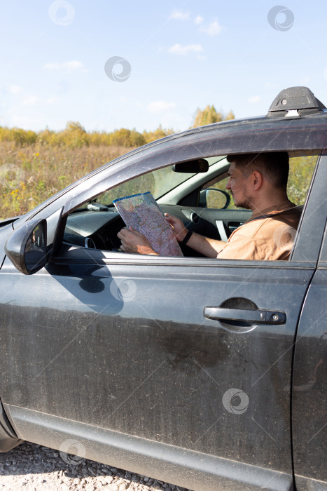 Скачать Мужчина в машине изучает дорожную карту фотосток Ozero