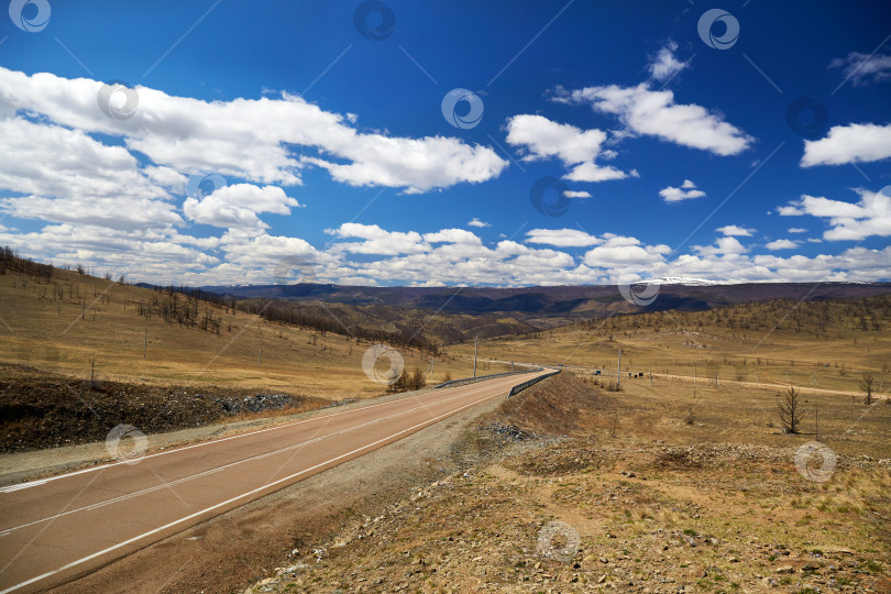 Скачать Асфальтированная пустая дорога к озеру Байкал. Прекрасный весенний пейзаж фотосток Ozero