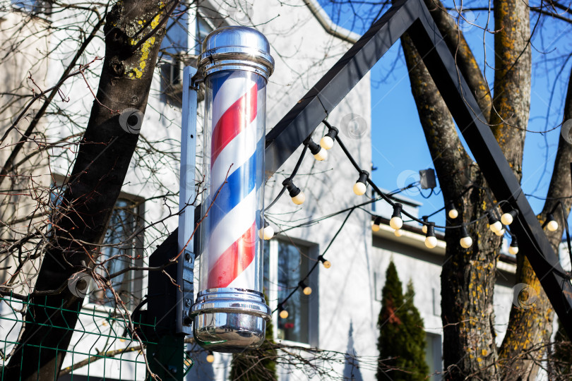 Скачать Городской пейзаж украшает патриотичный парикмахерский столб, висящий под голубым небом фотосток Ozero